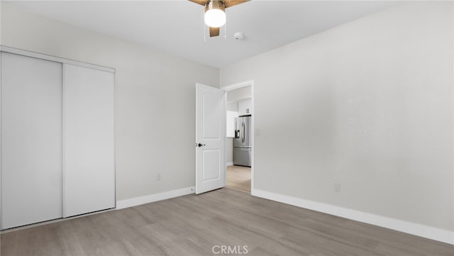 413 E 81st St, Los Angeles, CA 90003 - unfurnished bedroom featuring stainless steel refrigerator with ice dispenser, wood finished floors, a closet, baseboards, and a ceiling fan