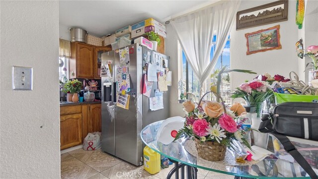 413 E 81st St, Los Angeles, CA 90003 - kitchen with stainless steel refrigerator with ice dispenser, brown cabinets, healthy amount of natural light, and a textured wall