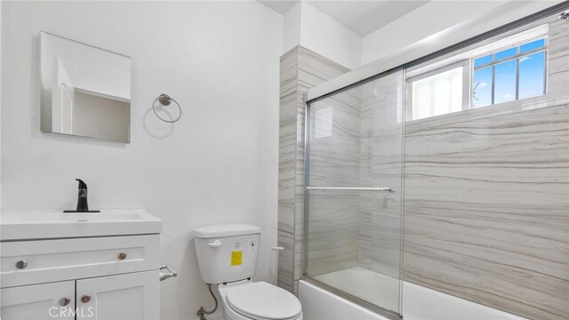 413 E 81st St, Los Angeles, CA 90003 - bathroom featuring toilet, vanity, and shower / bath combination with glass door