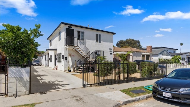 413 E 81st St, Los Angeles, CA 90003 - view of front of house with a fenced front yard, stucco siding, and stairs