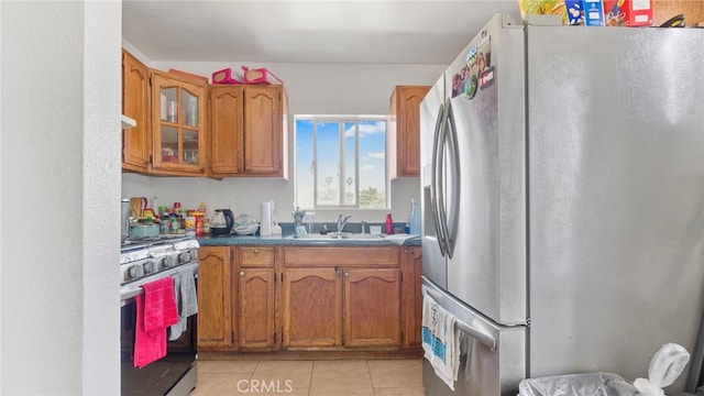 413 E 81st St, Los Angeles, CA 90003 - kitchen featuring appliances with stainless steel finishes, a sink, brown cabinets, and light tile patterned flooring