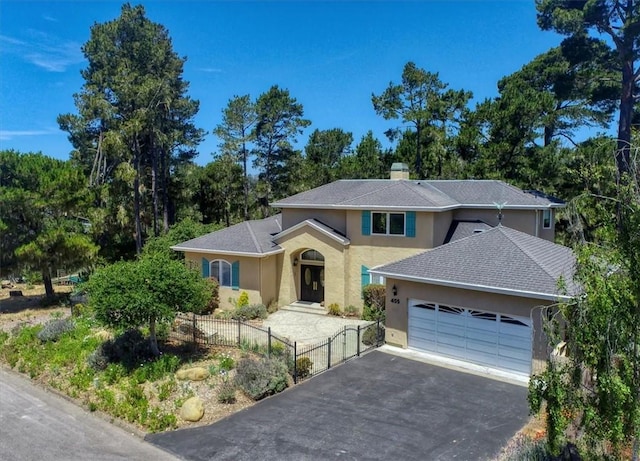 455 Chiswick Way, Cambria, CA 93428 - view of front facade with asphalt driveway, a garage, stucco siding, and a chimney