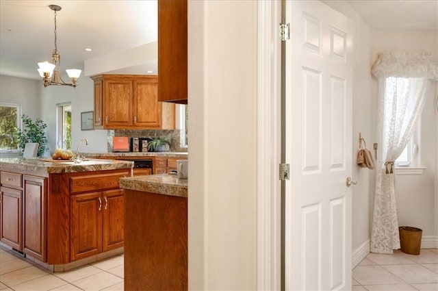 455 Chiswick Way, Cambria, CA 93428 - kitchen featuring light tile patterned floors, brown cabinetry, a chandelier, and pendant lighting