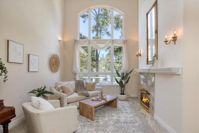 455 Chiswick Way, Cambria, CA 93428 - living room featuring a towering ceiling, a fireplace, and baseboards