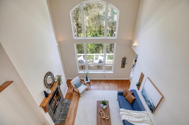 455 Chiswick Way, Cambria, CA 93428 - living area featuring wood finished floors, a high ceiling, a tile fireplace, and baseboards