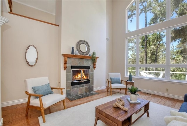 455 Chiswick Way, Cambria, CA 93428 - living area featuring a tile fireplace, wood finished floors, baseboards, and a high ceiling