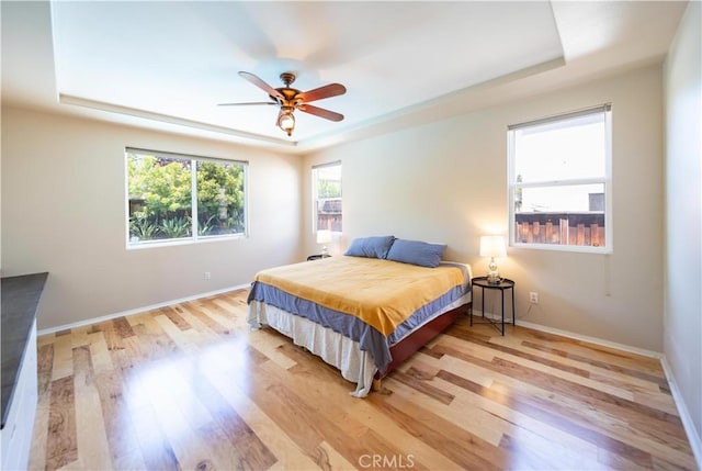 30802 Terrace View Cir, Temecula, CA 92591 - bedroom featuring a raised ceiling, light wood-type flooring, baseboards, and a ceiling fan