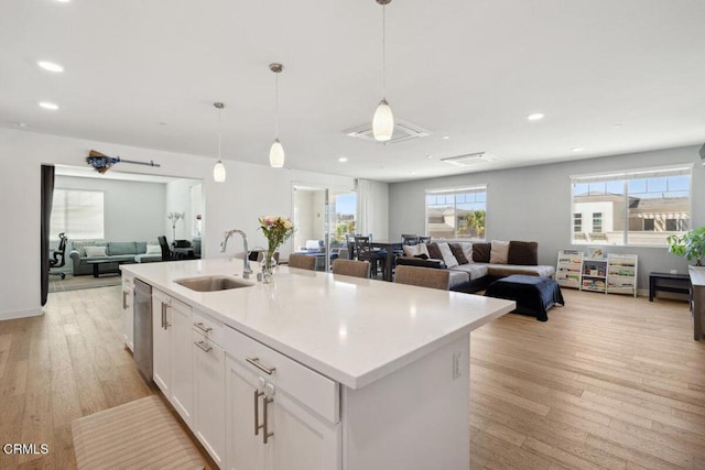 2800 Wagon Wheel Rd Unit 304, Oxnard, CA 93036 - kitchen featuring a sink, open floor plan, dishwasher, an island with sink, and white cabinetry