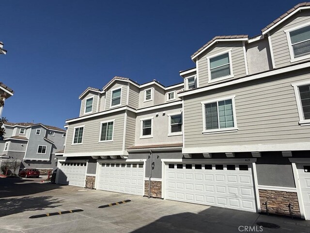 4617 Alekona Ct, Cypress, CA 90630 - view of property with stone siding, a garage, and stucco siding
