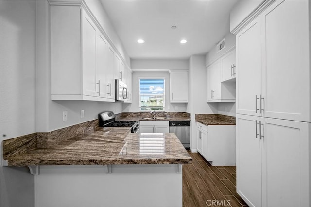4617 Alekona Ct, Cypress, CA 90630 - kitchen with stainless steel appliances, a peninsula, recessed lighting, white cabinetry, and dark stone counters