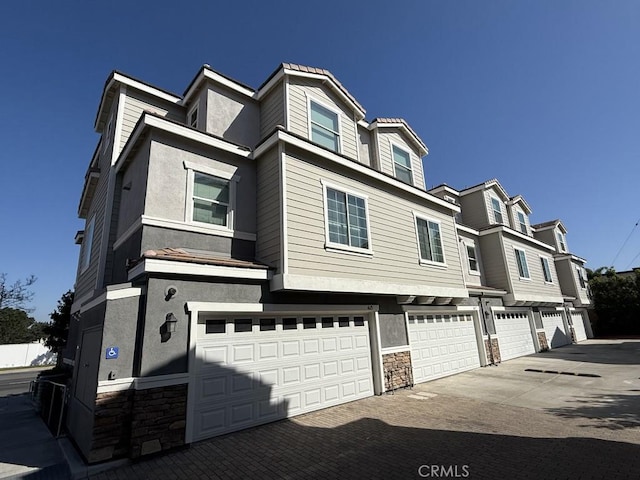 4615 Alekona Ct, Cypress, CA 90630 - view of front of property with a garage, stone siding, driveway, and stucco siding
