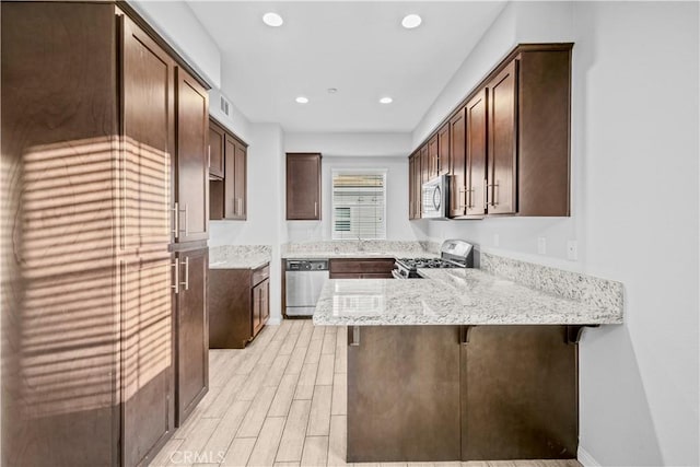 4615 Alekona Ct, Cypress, CA 90630 - kitchen featuring appliances with stainless steel finishes, a peninsula, light stone counters, light wood-type flooring, and recessed lighting