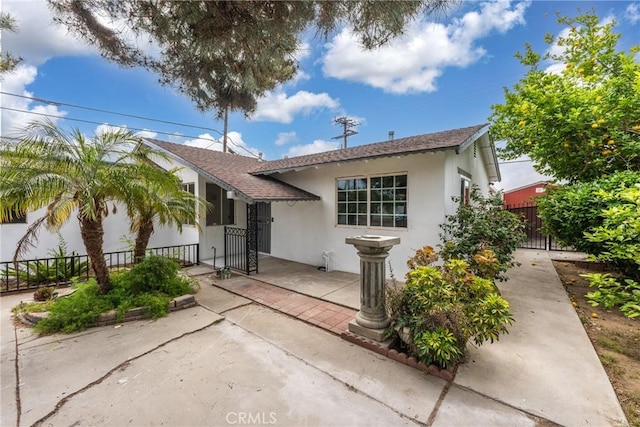 1089 W 2nd St, Rialto, CA 92376 - view of front facade featuring stucco siding, a gate, and roof with shingles