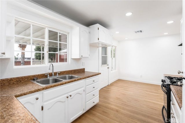 1089 W 2nd St, Rialto, CA 92376 - kitchen with a sink, black gas stove, white cabinets, light wood-type flooring, and recessed lighting