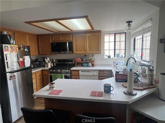 187 Woodbine Ln, Nipomo, CA 93444 - kitchen with stainless steel appliances, light countertops, a peninsula, and a breakfast bar