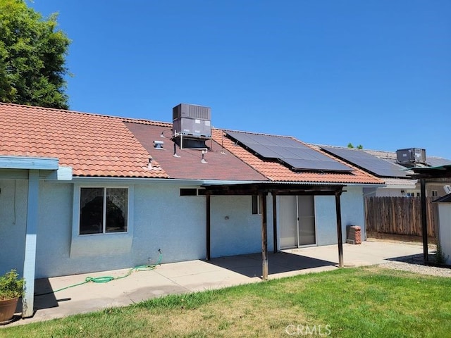 2368 Beechwood Way, Madera, CA 93637 - rear view of house with stucco siding, a patio area, roof mounted solar panels, central AC, and a tiled roof