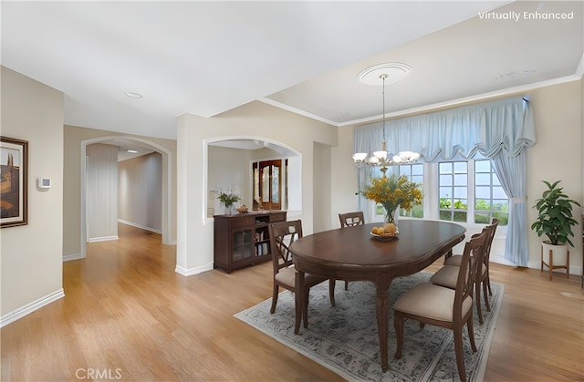 19371 Woodlands Dr, Huntington Beach, CA 92648 - dining space with arched walkways, light wood finished floors, baseboards, and crown molding
