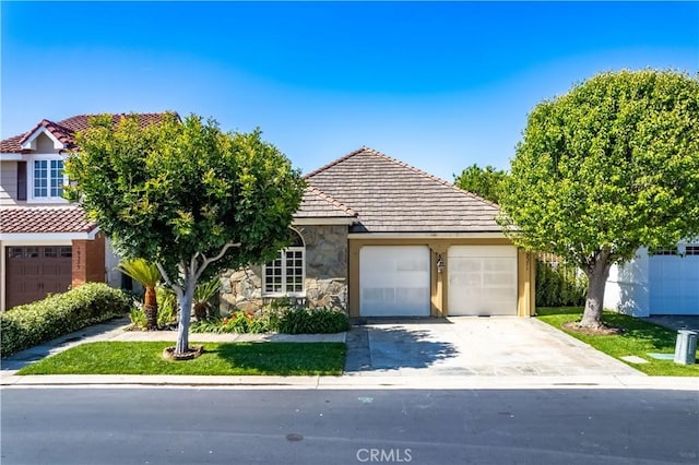 19371 Woodlands Dr, Huntington Beach, CA 92648 - view of front of house with a garage, stone siding, driveway, and a tile roof