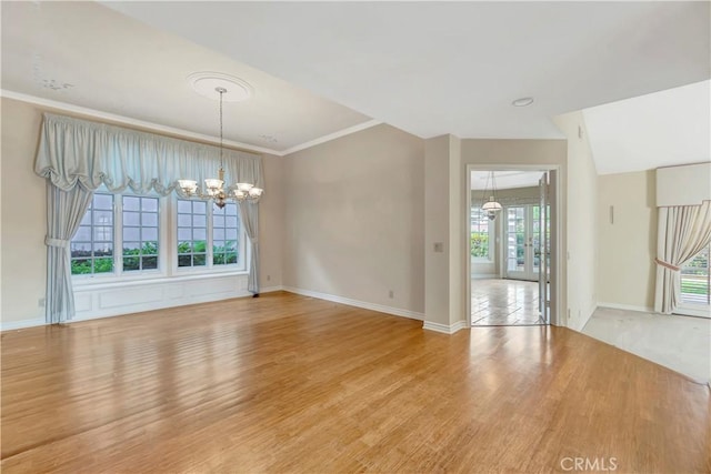 19371 Woodlands Dr, Huntington Beach, CA 92648 - spare room with a chandelier, light wood finished floors, baseboards, and ornamental molding