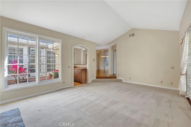 19371 Woodlands Dr, Huntington Beach, CA 92648 - unfurnished living room featuring light colored carpet, lofted ceiling, and baseboards