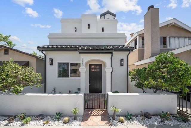 330 8th St, Seal Beach, CA 90740 - mediterranean / spanish-style home with a fenced front yard, stucco siding, a gate, and a tiled roof