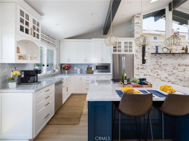 3504 Hightide Dr, Rancho Palos Verdes, CA 90275 - kitchen featuring appliances with stainless steel finishes, open shelves, light wood-style floors, backsplash, and a breakfast bar area