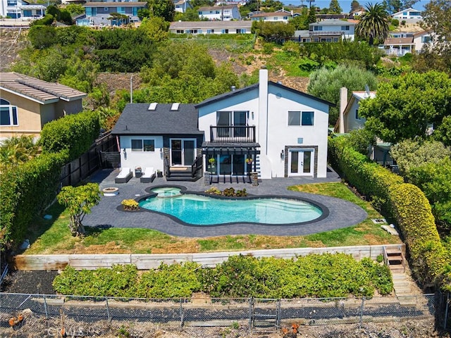 3504 Hightide Dr, Rancho Palos Verdes, CA 90275 - rear view of house with a balcony, a fenced backyard, stucco siding, a pool with connected hot tub, and french doors