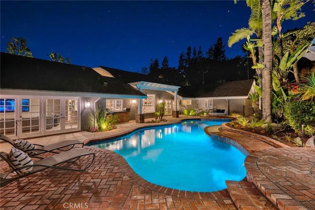 1821 Overview Cir, North Tustin, CA 92705 - pool at night with french doors, a patio, a pergola, and an outdoor pool