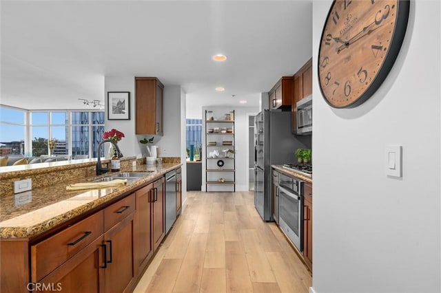 400 W Ocean Blvd Unit 605, Long Beach, CA 90802 - kitchen with appliances with stainless steel finishes, a peninsula, stone countertops, a sink, and light wood-style floors