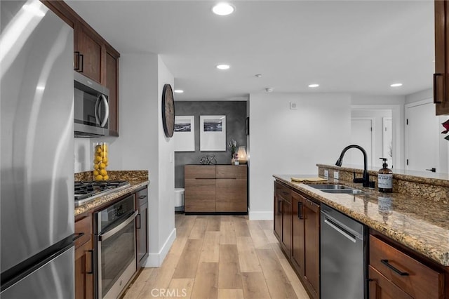 400 W Ocean Blvd Unit 605, Long Beach, CA 90802 - kitchen with appliances with stainless steel finishes, a sink, dark stone countertops, light wood finished floors, and recessed lighting