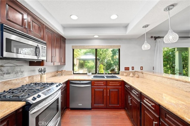 10139 Sun Valley Dr, Rancho Cucamonga, CA 91737 - kitchen with stainless steel appliances, a sink, a raised ceiling, wood finished floors, and hanging light fixtures