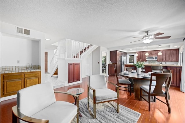 10139 Sun Valley Dr, Rancho Cucamonga, CA 91737 - dining room featuring stairway, ceiling fan, light wood finished floors, and a textured ceiling