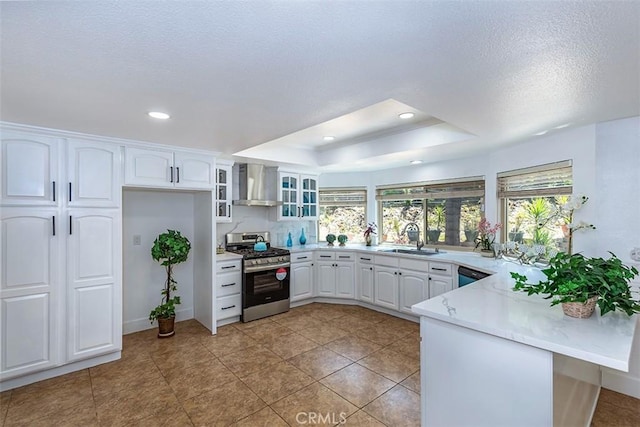 1250 Kinglake Dr, Diamond Bar, CA 91789 - kitchen featuring stainless steel range with gas stovetop, wall chimney range hood, a peninsula, a tray ceiling, and white cabinetry