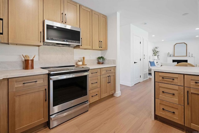 6871 Mewall Dr, San Diego, CA 92119 - kitchen featuring appliances with stainless steel finishes, light countertops, light wood-type flooring, recessed lighting, and light brown cabinetry