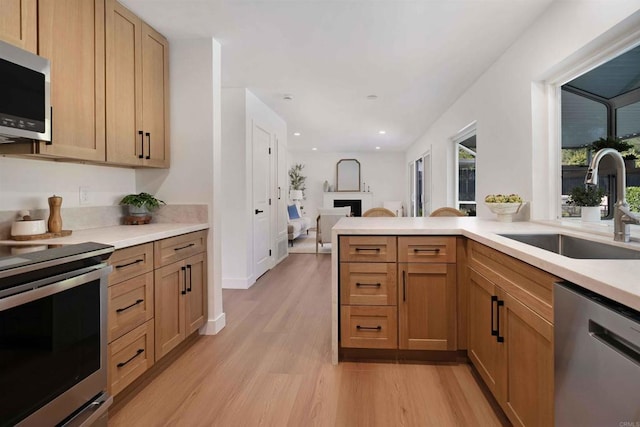 6871 Mewall Dr, San Diego, CA 92119 - kitchen featuring appliances with stainless steel finishes, a sink, light wood-style flooring, light countertops, and recessed lighting
