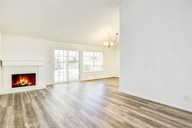 1919 Austin Ct, Claremont, CA 91711 - unfurnished living room featuring a chandelier, wood finished floors, a lit fireplace, baseboards, and lofted ceiling