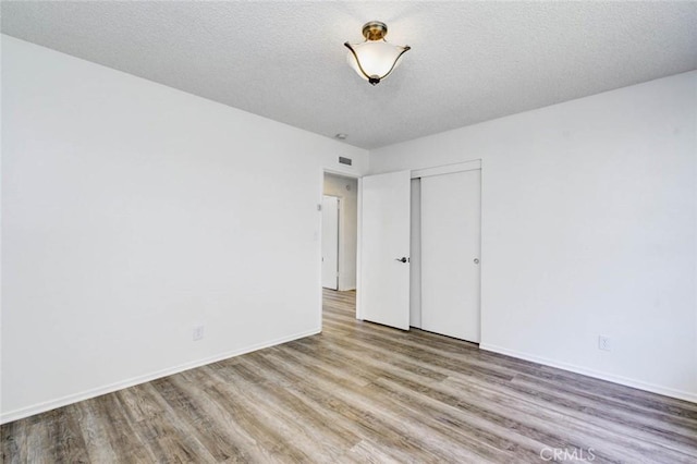 1919 Austin Ct, Claremont, CA 91711 - unfurnished bedroom with wood finished floors, a closet, baseboards, and a textured ceiling