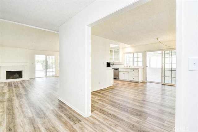 1919 Austin Ct, Claremont, CA 91711 - unfurnished living room with light wood-type flooring, a textured ceiling, a fireplace, and baseboards