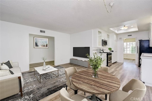 1919 Austin Ct, Claremont, CA 91711 - living room with light wood-style floors, a textured ceiling, and a tray ceiling