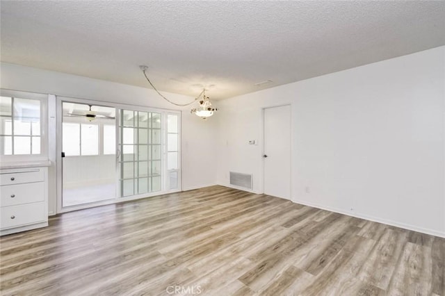 1919 Austin Ct, Claremont, CA 91711 - unfurnished room with light wood-style flooring, a chandelier, a textured ceiling, and baseboards