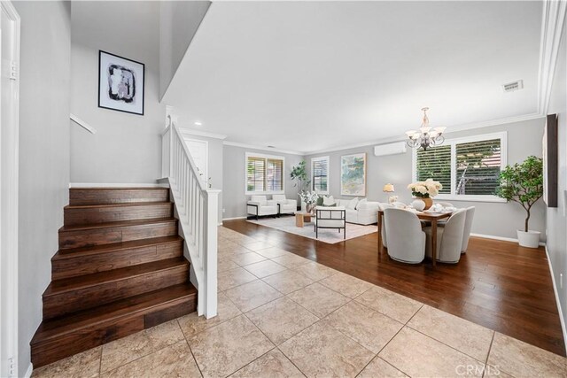 7626 Soaring Bird Ct, Eastvale, CA 92880 - stairs with ornamental molding, tile patterned flooring, a chandelier, baseboards, and an AC wall unit