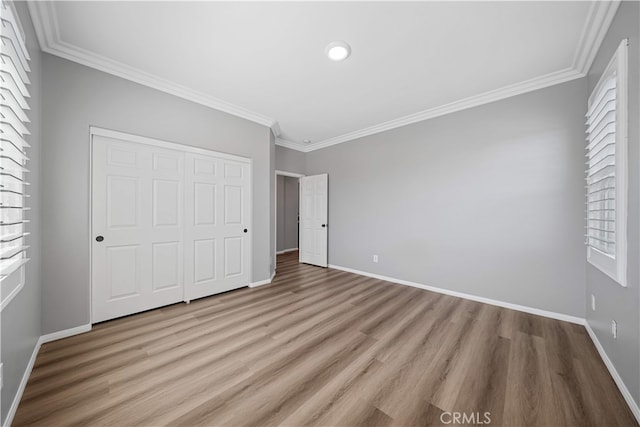 7626 Soaring Bird Ct, Eastvale, CA 92880 - unfurnished bedroom featuring light wood-type flooring, ornamental molding, a closet, multiple windows, and baseboards