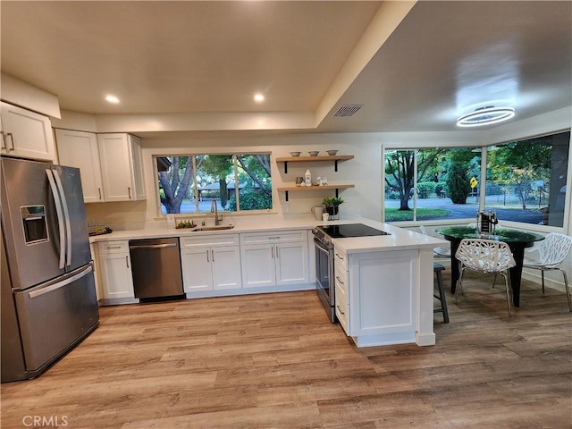 48 Pine Oaks Rd, Oroville, CA 95966 - kitchen with appliances with stainless steel finishes, light countertops, white cabinets, a peninsula, and healthy amount of natural light