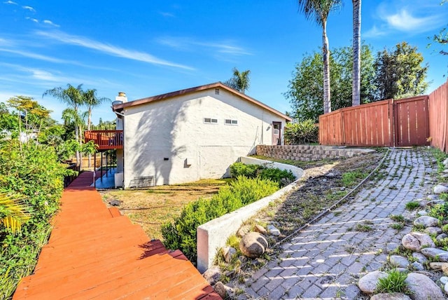 2548 Katherine Ct, El Cajon, CA 92020 - view of side of home featuring stucco siding, a deck, and a chimney