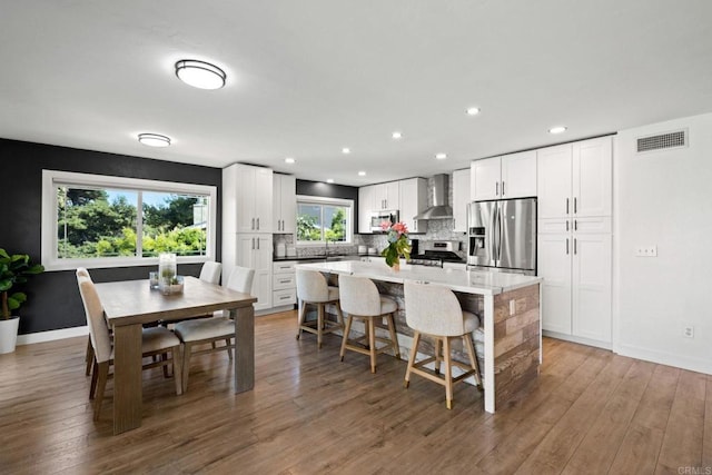 2548 Katherine Ct, El Cajon, CA 92020 - kitchen with appliances with stainless steel finishes, wall chimney range hood, a kitchen island, recessed lighting, and a breakfast bar