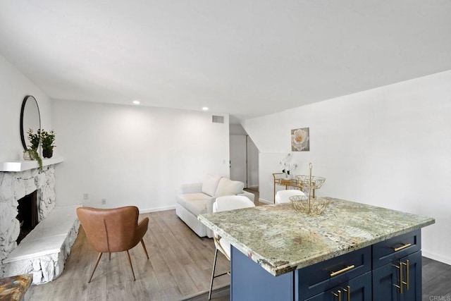 2548 Katherine Ct, El Cajon, CA 92020 - kitchen with blue cabinets, a breakfast bar, wood finished floors, baseboards, and a fireplace