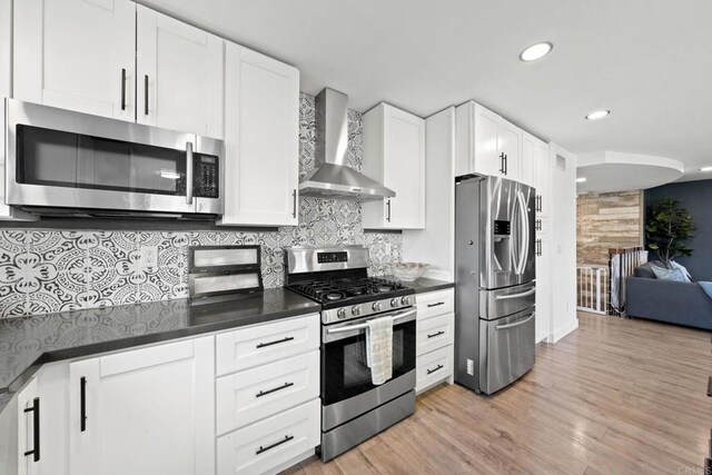 2548 Katherine Ct, El Cajon, CA 92020 - kitchen featuring stainless steel appliances, wall chimney exhaust hood, dark countertops, tasteful backsplash, and light wood-type flooring