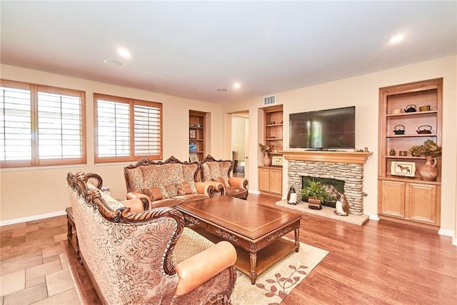 12430 Split Rein Dr, Rancho Cucamonga, CA 91739 - living area with built in shelves, a fireplace, baseboards, and recessed lighting