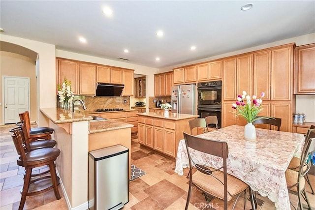 12430 Split Rein Dr, Rancho Cucamonga, CA 91739 - kitchen featuring black appliances, recessed lighting, arched walkways, backsplash, and a breakfast bar