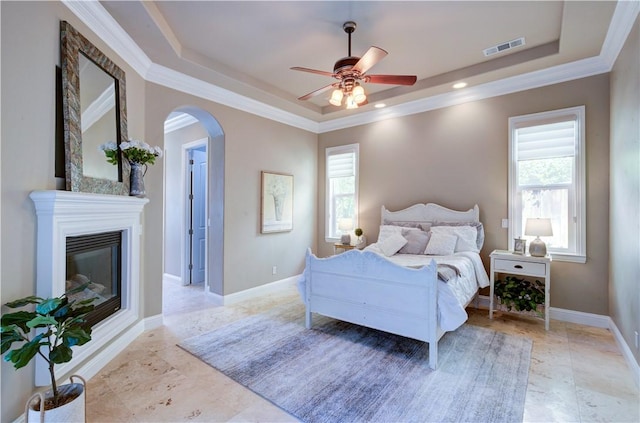 2096 E Olympic Ave, Fresno, CA 93730 - bedroom featuring a raised ceiling, arched walkways, ornamental molding, a glass covered fireplace, and baseboards